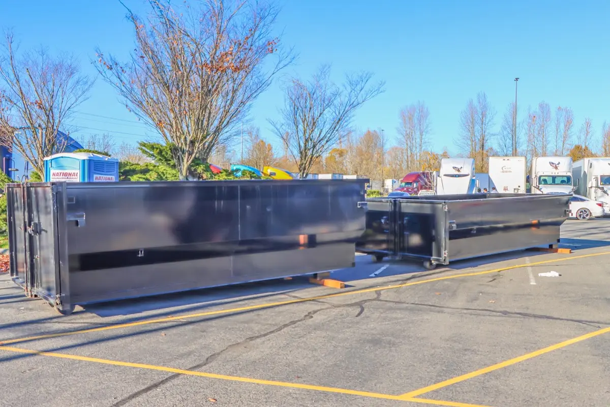 Professional dumpster rental service with roll-off container on residential driveway in East Riverdale
